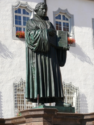 Das Lutherdenkmal in Wittenberg – der Reformator verweist auf die Bibel als Grundlage des Glaubens. Foto: Hansjörg Keller / pixelio.de